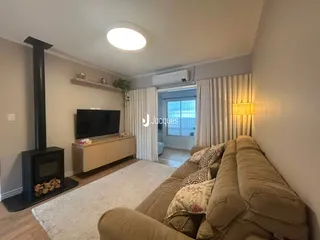 Sala de estar com sofá e lareira em um apartamento no Brasil.