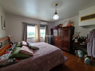 Quarto com cama de madeira e armário de madeira.