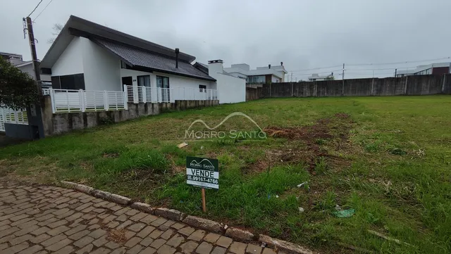 Fachada de uma casa branca com um grande gramado em Lajeado, Brasil.