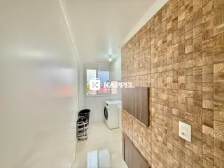 Corredor interno com paredes brancas e revestimento de madeira na parede direita.