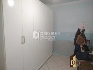 Vista de um corredor com armários brancos.