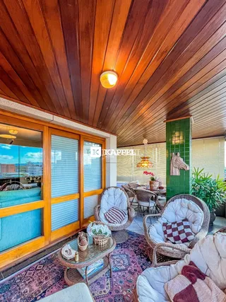 Sala de estar com móveis de vime e teto de madeira.