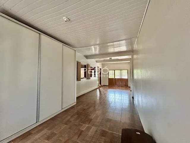 Corredor interno de uma residência com armários embutidos e piso de cerâmica.