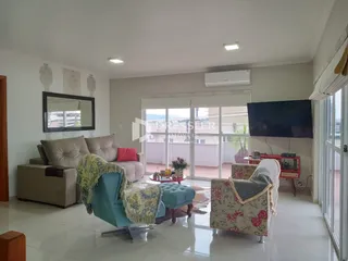 Sala de estar com sofá e poltronas em um ambiente claro.