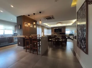 Ambiente interno de uma sala de jantar com piso de madeira e móveis de madeira.