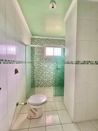 Foto de um banheiro com revestimento cerâmico nas paredes e piso.