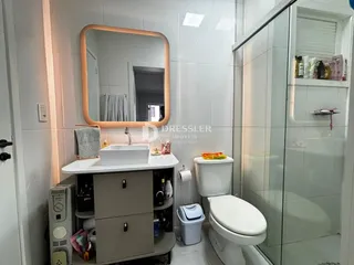 A foto mostra o interior de um banheiro com box de vidro.