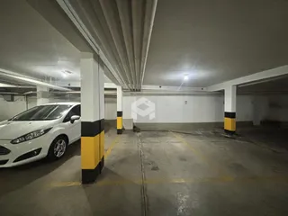 Área de estacionamento coberta com pilares amarelos e pretos.