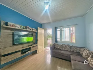 Sala de estar com sofá e televisão em um apartamento no Brasil.