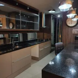 Foto de uma cozinha com armários e bancadas escuras.