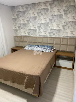 Foto de um quarto com cama e cabeceira em um imóvel.