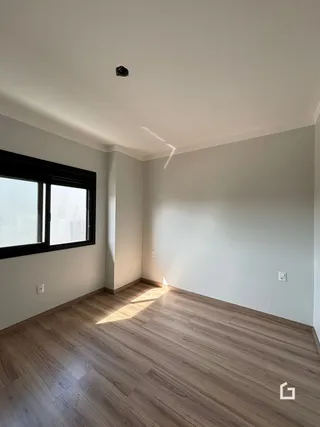 Foto de um cômodo com piso de madeira e janela em uma residência.
