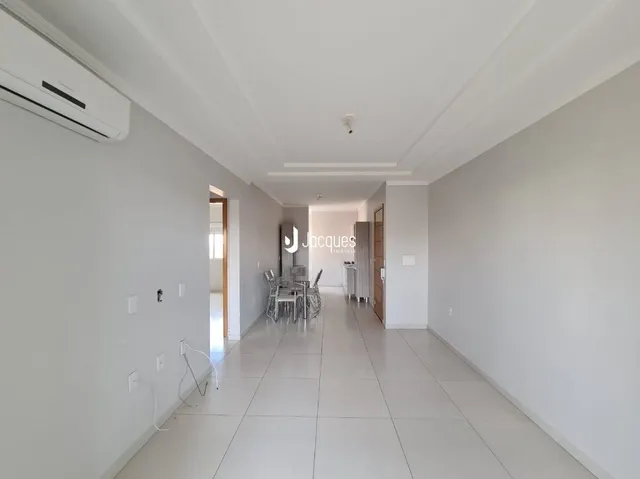 Corredor interno de uma residência com paredes brancas e piso claro.
