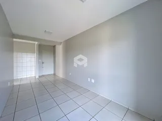 Corredor interno com piso de cerâmica clara e paredes brancas.