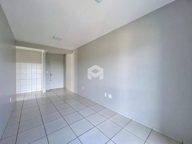 Corredor interno com piso de cerâmica clara e paredes brancas.
