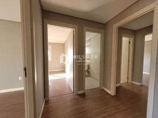 Hall de entrada com piso de madeira e portas internas.