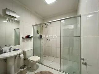 Foto de um banheiro com revestimento cerâmico branco.