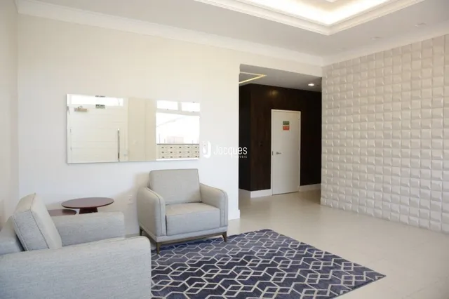 Sala de estar com paredes brancas e piso claro.