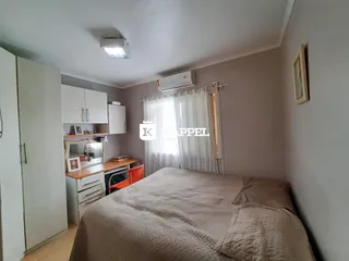Quarto com cama grande e armários brancos.