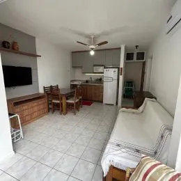 Quarto com cama e piso de cerâmica claro.