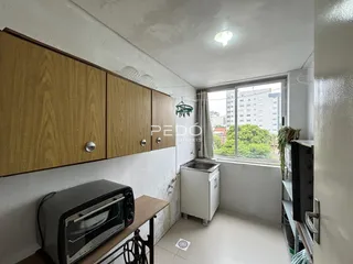 Foto de uma cozinha com armários de madeira e janela.
