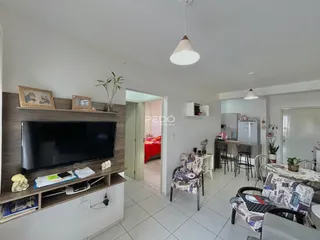 Sala de estar com televisão e estantes de madeira em um imóvel no Brasil.