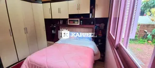 Quarto com cama e armários de madeira em um ambiente interno.