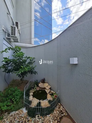 Vista da fachada de uma residência com jardim e vegetação.