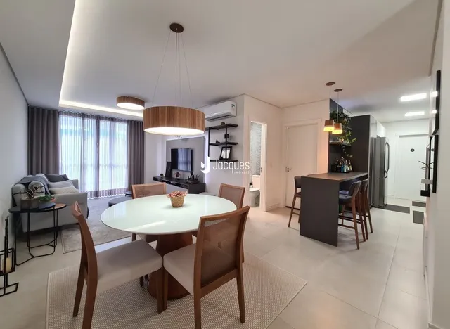 Sala de estar com mesa de jantar e sofá em um apartamento.