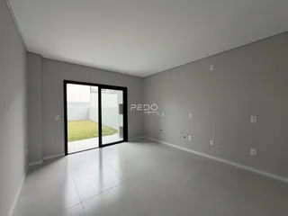 Interior de um ambiente com porta de vidro abrindo para um jardim.