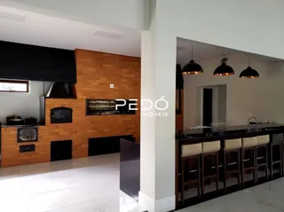 Interior de uma sala com parede de madeira e bancada de cozinha.