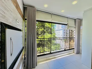 Sala de estar com vista para o jardim através de uma grande janela.