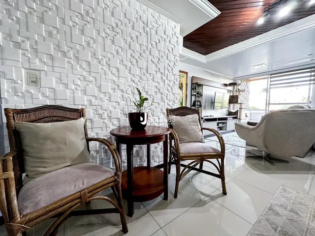 Sala de estar com cadeiras de vime e piso de cerâmica claro.
