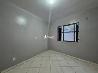 Vista de um corredor interno com paredes cinzas e piso de cerâmica clara.
