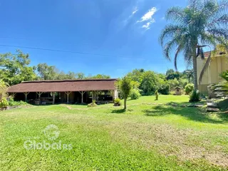 Vista externa de um terreno com gramado e vegetação.
