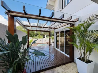 Área externa com deck de madeira e vegetação.