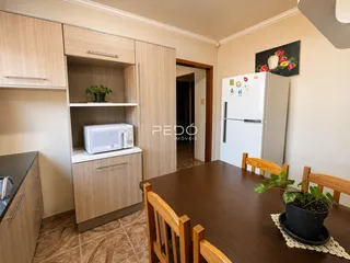 Foto de uma cozinha com armários de madeira e mesa de jantar.
