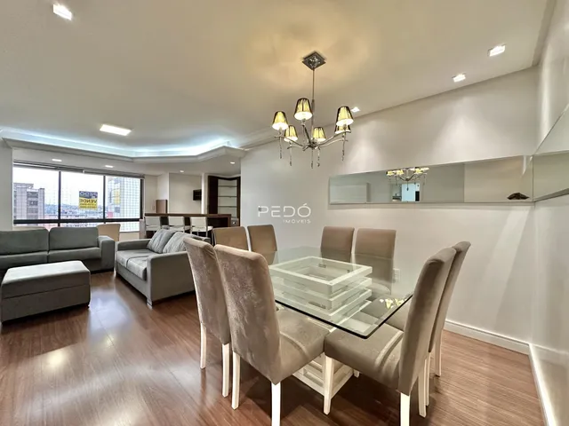 Sala de estar e jantar com piso de madeira no imóvel.