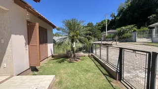 Fachada de uma casa em Lajeado, Brasil, com jardim gramado e cerca de madeira.