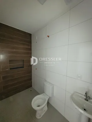 Foto de um banheiro interno com revestimento cerâmico branco.