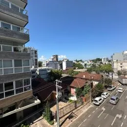 Vista externa de edifícios residenciais em Lajeado, Brasil, sob um céu azul.