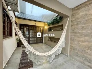 Ambiente interno com uma rede pendurada em um espaço de estar.