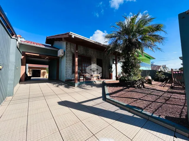 Foto da fachada de uma residência em Lajeado, Brasil, com área externa e jardim.
