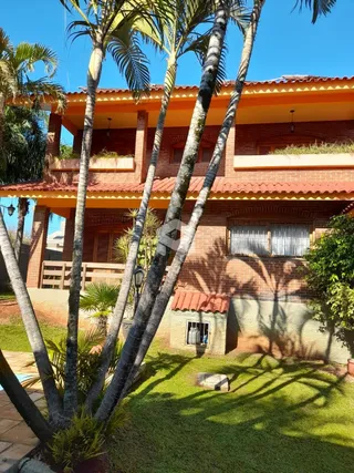 Fachada de uma casa com telhado de telhas e jardim gramado em Lajeado.
