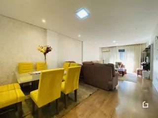 Sala de estar com cadeiras amarelas e piso de madeira.