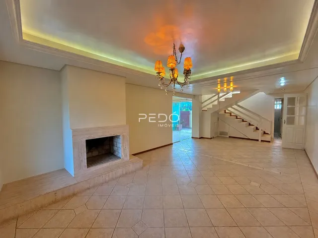 Área de hall com lareira e escadaria em um imóvel.