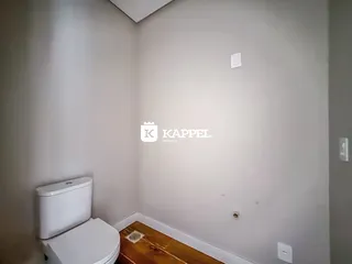 Foto de um banheiro mostrando um vaso sanitário e piso de madeira.