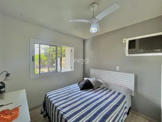 Quarto com cama e janela de luz natural.