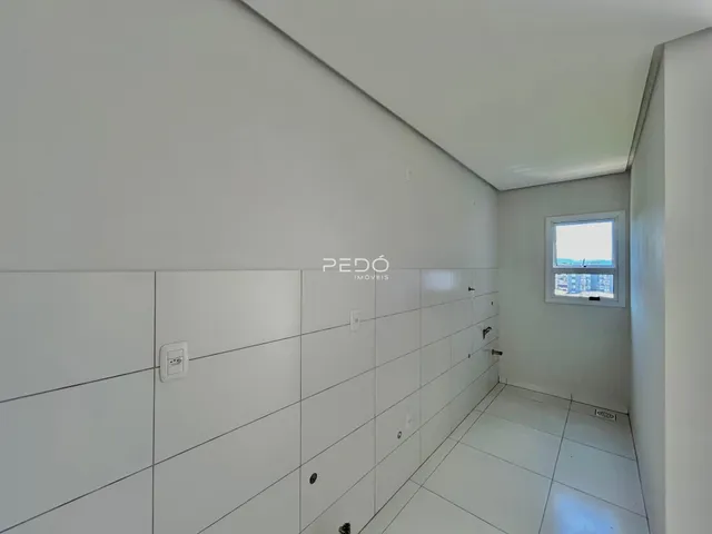 Corredor interno de uma residência com paredes brancas e piso claro.
