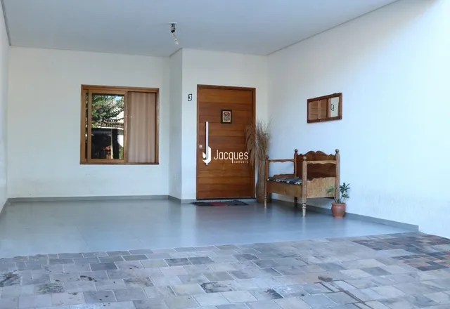 Ambiente interno de uma sala com piso de cerâmica e porta de madeira.